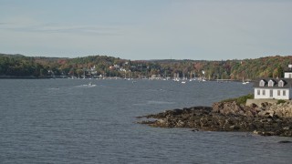 AX148_090E - 6K aerial stock footage flying by Indian Island Light to Lockport Harbor, small town, autumn, Rockport, Maine