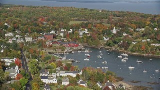 AX148_098E - 6K aerial stock footage orbiting small coastal town, Rockport Harbor, autumn, Rockport, Maine