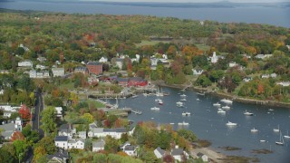AX148_099 - 6k stock footage aerial video orbiting small coastal town, Rockport Harbor, autumn, Rockport, Maine