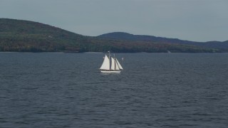 AX148_104 - 6k aerial stock footage tracking a sailboat, West Penobscot Bay, autumn, Rockport, Maine