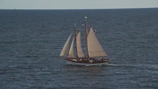 AX148_104E - 6K aerial stock footage tracking a sailboat, West Penobscot Bay, autumn, Rockport, Maine