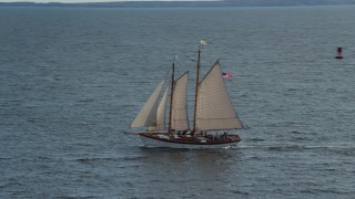 AX148_106 - 6k aerial stock footage orbiting a sailboat on West Penobscot Bay, Rockport, Maine