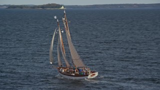 AX148_107E - 6K aerial stock footage orbiting a sailboat on West Penobscot Bay, Rockport, Maine