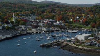 AX148_111 - 6k stock footage aerial video flying over Camden Harbor, approach small coastal town, autumn, Camden, Maine