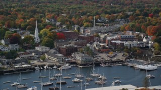 AX148_112 - 6K aerial stock footage flying by small coastal town near harbor, autumn, Camden, Maine