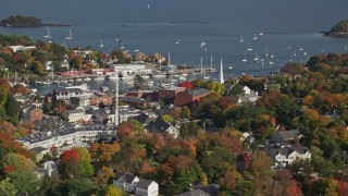 AX148_114E - 6K aerial stock footage orbiting small coastal town, Camden Harbor, autumn, Camden, Maine