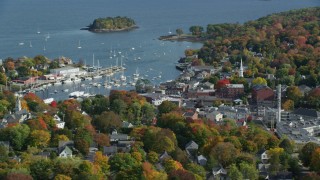 AX148_115 - 6k stock footage aerial video orbiting small coastal town, Camden Harbor, autumn, Camden, Maine
