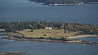 AX148_132 - 6K aerial stock footage approaching an isolated homes, autumn, Hog Island, Maine