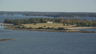 AX148_133 - 6K aerial stock footage approaching an isolated island home in autumn, Hog Island, Maine