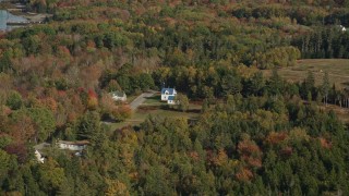 AX148_137 - 6K aerial stock footage approaching island homes, colorful trees in autumn, Little Deer Isle, Maine