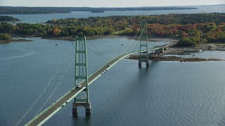 AX148_142 - 6k aerial stock footage orbiting the Deer Isle Bridge, colorful trees in autumn, Little Deer Isle, Maine