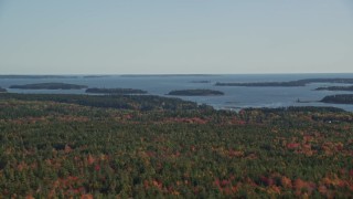 AX148_150 - 6K aerial stock footage flying by colorful forest, small islands in the bay, autumn, Brooklin, Maine