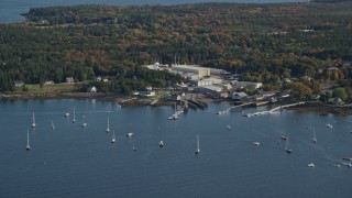 AX148_162 - 5.5K aerial stock footage flying by waterfront warehouse buildings, autumn, Southwest Harbor, Maine