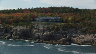 AX148_173 - 5.5K aerial stock footage approaching an isolated waterfront mansion, autumn, Seal Harbor, Maine