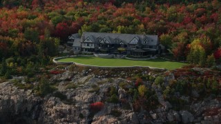 AX148_173E - 5.5K aerial stock footage approaching an isolated waterfront mansion, autumn, Seal Harbor, Maine