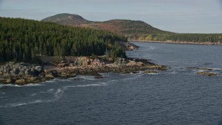 AX148_175E - 5.5K aerial stock footage flying by a forested coastline, Seal Harbor, Mount Desert Island, Maine