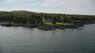 AX148_192E - 5.5K aerial stock footage approaching waterfront homes, autumn, Bar Harbor, Maine