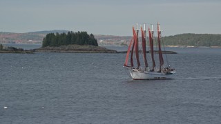 AX148_195 - 5.5K aerial stock footage tracking a sailing ship by a tiny island, Bar Harbor, Maine