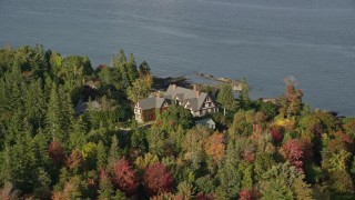 AX148_215E - 5.5K aerial stock footage flying by isolated waterfront home and fall foliage, Bar Harbor, Maine