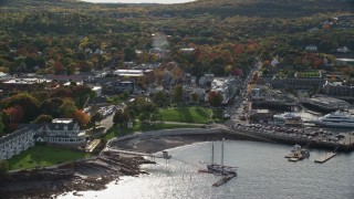 AX148_219E - 5.5K aerial stock footage of fall foliage in a coastal town near the harbor, Bar Harbor, Maine
