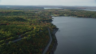 AX148_225 - 5.5K aerial stock footage flying over water and forest with fall foliage, Bar Harbor, Maine