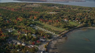 AX148_226E - 5.5K aerial stock footage approaching cottages among a coastal community and fall foliage, autumn, Bar Harbor, Maine