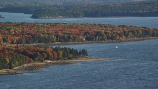 AX149_006E - 5.5K aerial stock footage of a forest with fall foliage along a cove, Trenton, Maine