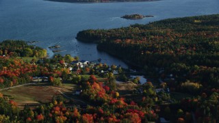 AX149_013 - 5.5K aerial stock footage flying by coastal neighborhood among fall foliage, Blue Hill, Maine