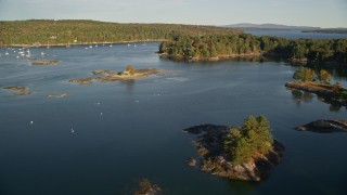 AX149_023 - 5.5K aerial stock footage flying over water toward tiny islands and trees, autumn, Blue Hill, Maine