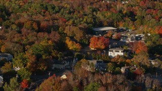 AX149_030 - 5.5K aerial stock footage passing houses in a small town, fall foliage, Blue Hill, Maine