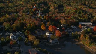 AX149_031E - 5.5K aerial stock footage passing by a small coastal town and fall foliage, Blue Hill, Maine