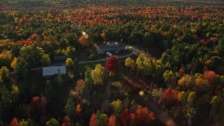 AX149_038 - 5.5K aerial stock footage flying over and tilt down on isolated home among fall foliage, Blue Hill, Maine