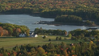 AX149_063E - 5.5K aerial stock footage flying by an isolated home, colorful foliage, autumn, Penobscot, Maine