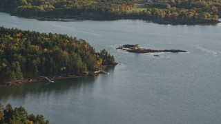 AX149_065 - 5.5K aerial stock footage flying by an isolated waterfront home, colorful trees, autumn, Penobscot, Maine