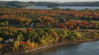 AX149_068 - 5.5K aerial stock footage flying by rural waterfront homes, colorful forest, autumn, Penobscot, Maine