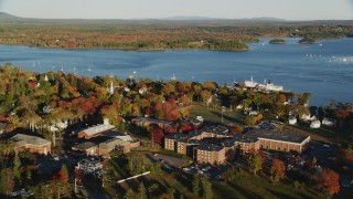AX149_074 - 5.5K aerial stock footage orbiting Maine Maritime Academy nestled among fall foliage, autumn, Castine, Maine