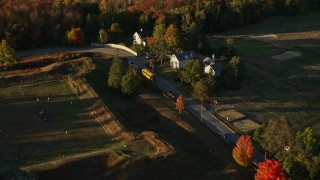 AX149_082 - 5.5K aerial stock footage approaching and flying by houses, school bus in a small town, autumn, Castine, Maine