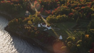AX149_088E - 5.5K aerial stock footage flying by Fort Point Light, among fall foliage, autumn, Stockton Springs, Maine