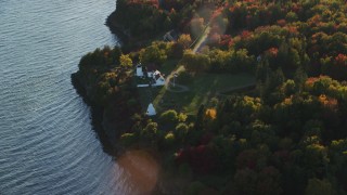 AX149_089 - 5.5K aerial stock footage flying by Fort Point Light, colorful trees in autumn, Stockton Springs, Maine