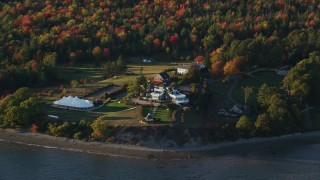AX149_090 - 5.5K aerial stock footage flying by French's Point in front of colorful forest, autumn, Stockton Springs, Maine