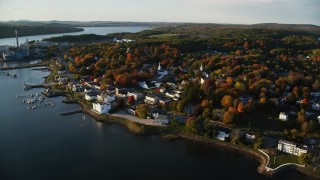 AX149_104 - 5.5K aerial stock footage orbiting small coastal town, colorful trees, autumn, Bucksport, Maine
