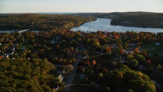 AX149_111 - 5.5K aerial stock footage approaching Penobscot Narrows Bridge from over small town, autumn, Bucksport, Maine