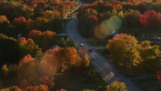 AX149_141 - 5.5K aerial stock footage tracking car on road through quaint town, autumn, Stockton Springs, Maine, sunset