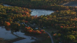 AX149_157 - 5.5K aerial stock footage flying by ponds surrounded by forest in autumn, Belfast, Maine, sunset