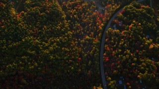 AX149_165 - 5.5K aerial stock footage of a bird's eye view over forest and rural homes in autumn, Belfast, Maine, sunset