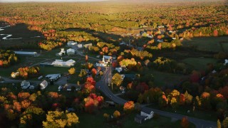 AX149_178 - 5.5K aerial stock footage orbiting a small rural town in autumn, Searsmont, Maine, sunset