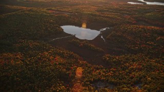 AX149_194 - 5.5K aerial stock footage approaching Colby Pond, tilt down, autumn, Palermo, Maine, sunset
