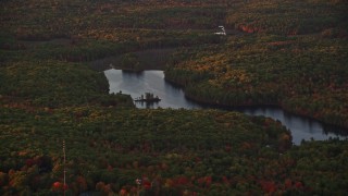 AX149_212 - 5.5K aerial stock footage flying by colorful foliage, Tolman Pond, autumn, Augusta, Maine, sunset