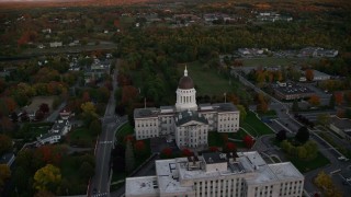AX149_215E - 5.5K aerial stock footage flying by the Maine State House, autumn, Augusta, Maine, sunset