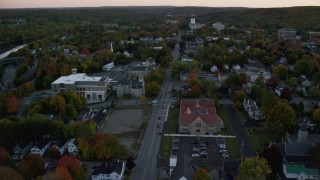 AX149_224 - 5.5K aerial stock footage flying over downtown in autumn, approach Lithgow Public Library, Augusta, Maine, twilight